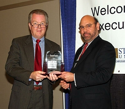On the left, John Cox, Director of Information Resources, Texas Higher Education Coordinating Board is honored as Austin's IT Executive of the Year (Public Sector) by award sponsor St. Edwards' Rudy Rodriquez